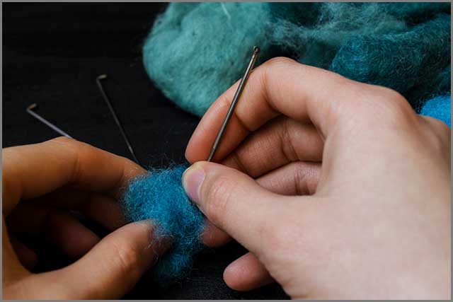 A person working with a felting needle