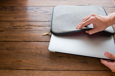 hand pulling laptop out of laptop bag