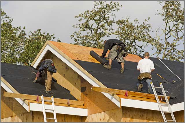 Workers installing a roof felt