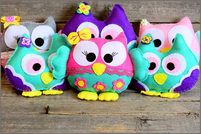 Owl toys made of wool felt on a wooden background
