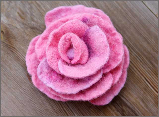 A pink rose flower made of natural wool felt