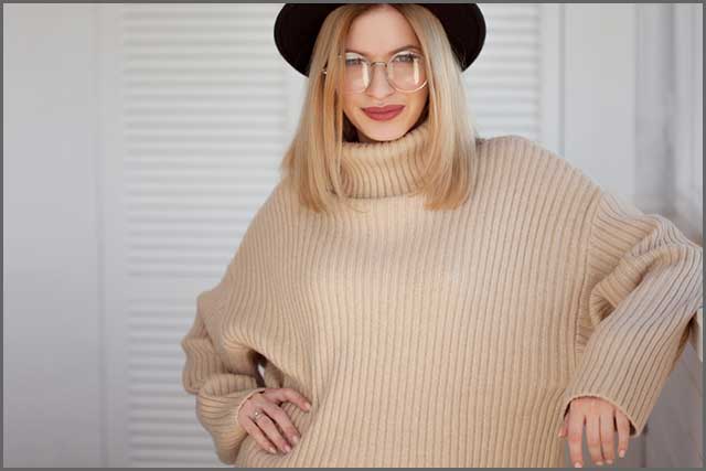 Felt hat and beige sweater worn by a beautiful woman