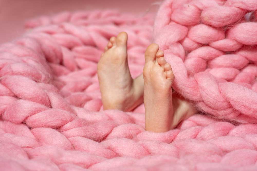 child in a chunky wool blanket